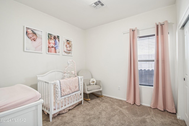 bedroom featuring a nursery area and light carpet