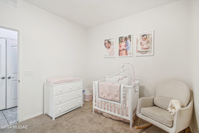 bedroom with a nursery area and light carpet