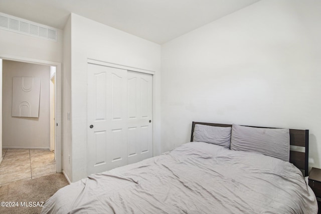 bedroom featuring light carpet and a closet