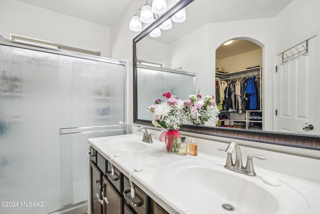 bathroom with a shower with shower door and vanity