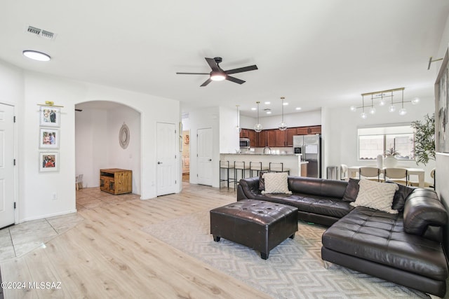 living room with ceiling fan, sink, and light hardwood / wood-style floors