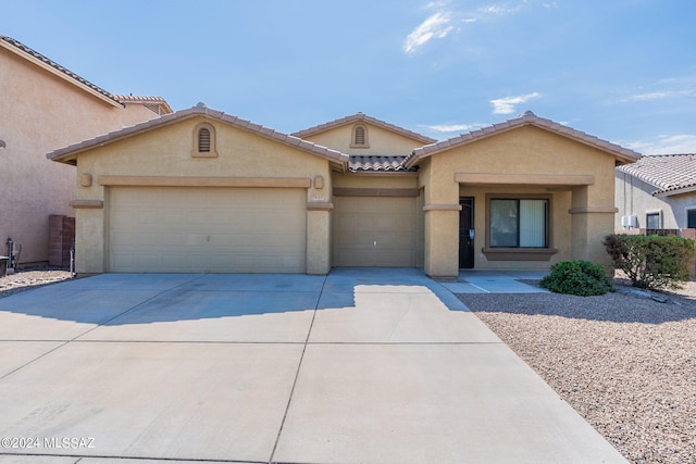 ranch-style home with stucco siding, a tile roof, driveway, and a garage