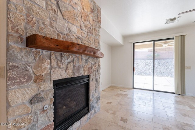 unfurnished living room with a fireplace, visible vents, and baseboards