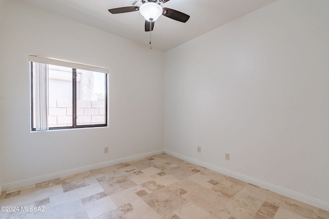 unfurnished room featuring a ceiling fan and baseboards