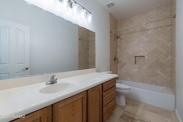 full bathroom featuring vanity, tiled shower / bath combo, and toilet