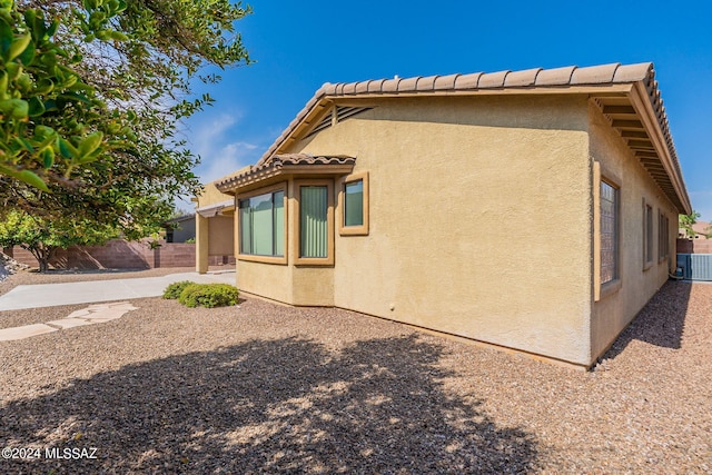 view of home's exterior featuring fence, a patio, and stucco siding