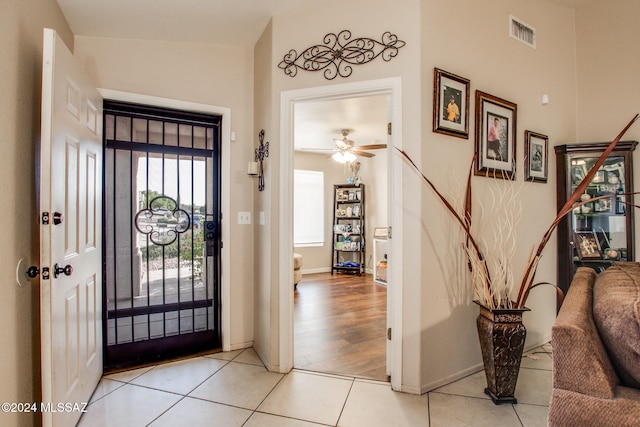 foyer entrance featuring lofted ceiling, ceiling fan, and light hardwood / wood-style flooring