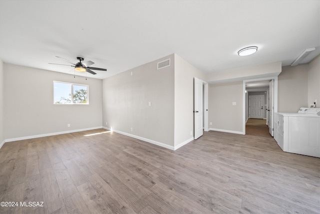 empty room with light hardwood / wood-style floors, washing machine and dryer, and ceiling fan