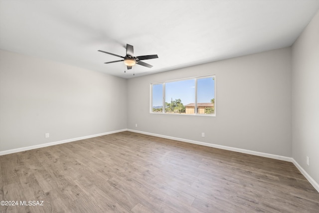 spare room featuring wood-type flooring and ceiling fan