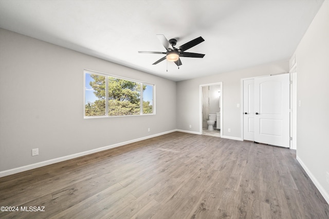 unfurnished bedroom with wood-type flooring, ensuite bath, and ceiling fan