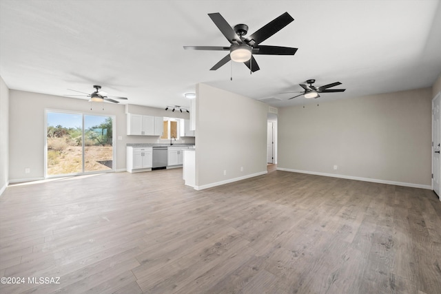 unfurnished living room with light wood-type flooring and ceiling fan