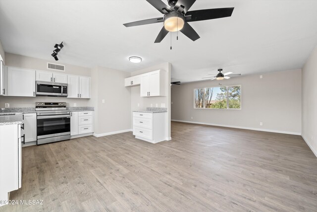 kitchen featuring white cabinetry, light stone counters, stainless steel appliances, ceiling fan, and light hardwood / wood-style flooring