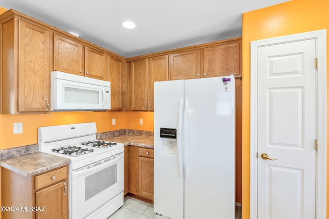 kitchen with white appliances and light tile patterned flooring