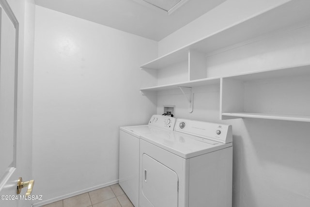 laundry room with washing machine and clothes dryer and light tile patterned floors