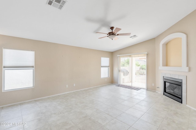 unfurnished living room with vaulted ceiling, ceiling fan, light tile patterned flooring, and a fireplace