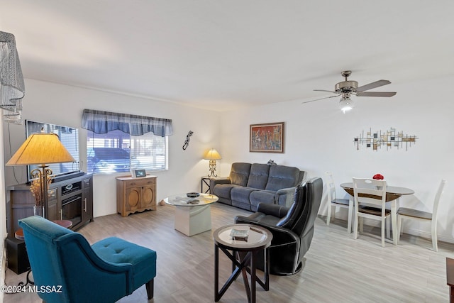 living room with light hardwood / wood-style flooring and ceiling fan