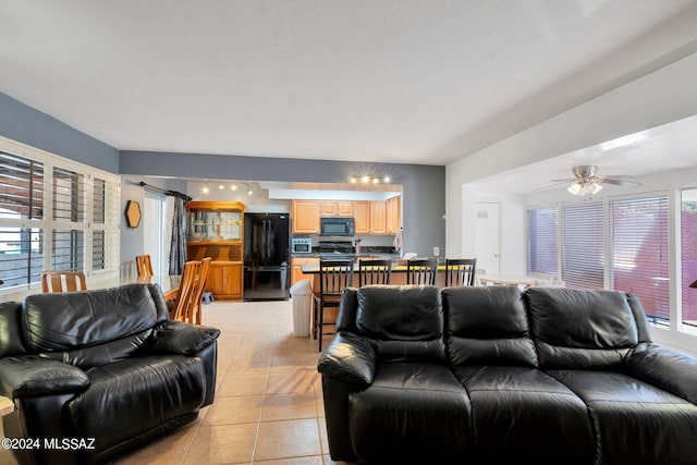 tiled living room featuring ceiling fan and plenty of natural light