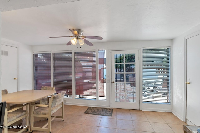 dining room with a healthy amount of sunlight, ceiling fan, and light tile patterned floors