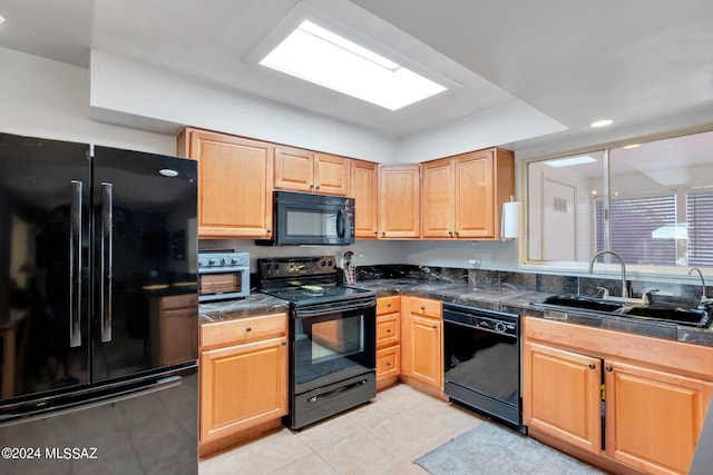 kitchen featuring light tile patterned flooring, sink, and black appliances