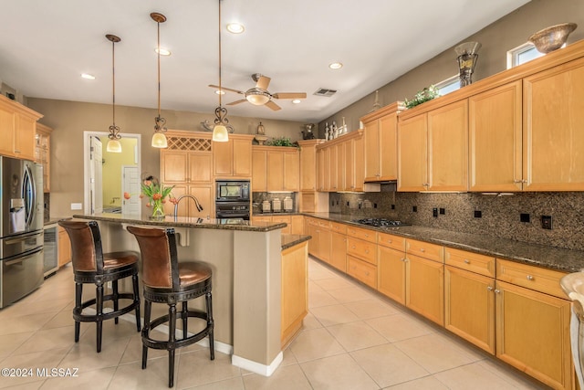 kitchen featuring light tile patterned floors, backsplash, black appliances, an island with sink, and decorative light fixtures