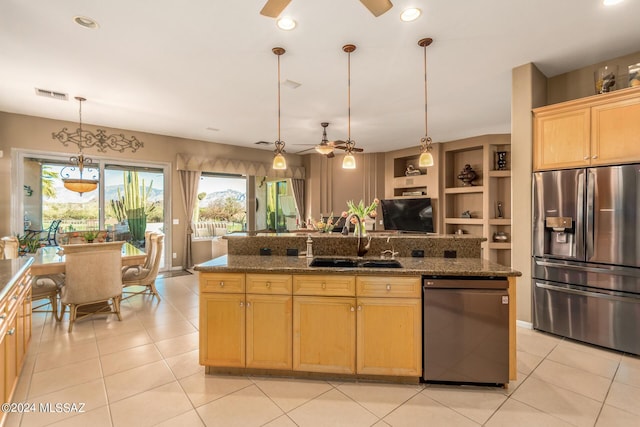 kitchen featuring black dishwasher, sink, dark stone counters, and stainless steel fridge with ice dispenser