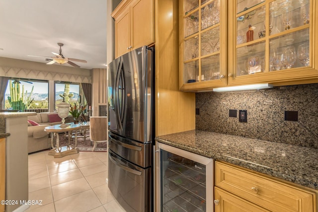 kitchen featuring wine cooler, light tile patterned floors, fridge, dark stone counters, and decorative backsplash