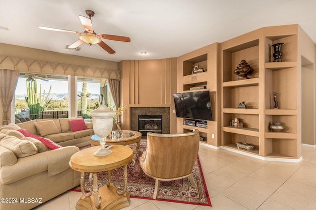 tiled living room featuring ceiling fan and built in shelves