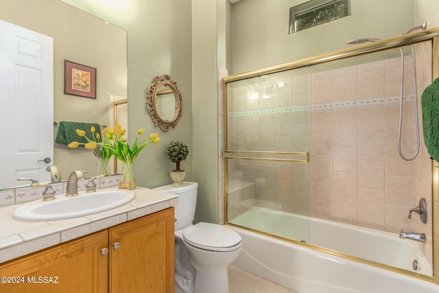 full bathroom with enclosed tub / shower combo, vanity, tile patterned floors, and toilet