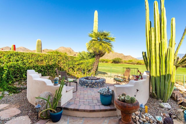 view of patio / terrace featuring a mountain view and a fire pit