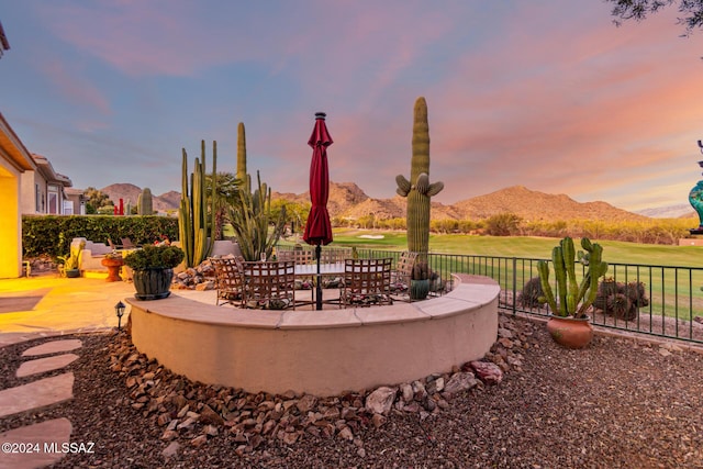 yard at dusk with a patio and a mountain view