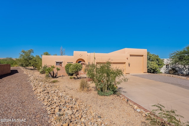 pueblo-style home featuring a garage