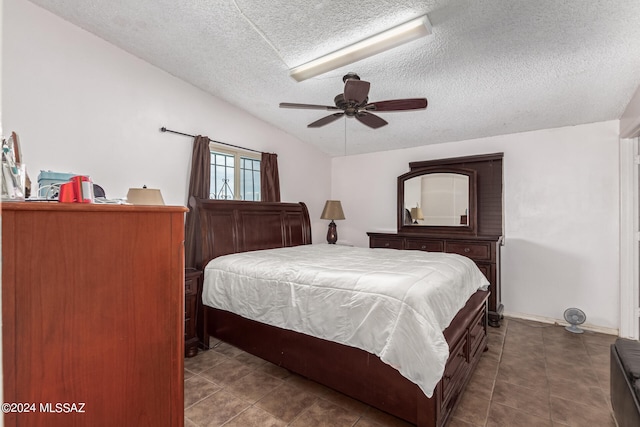 bedroom featuring tile patterned flooring, vaulted ceiling, a textured ceiling, and ceiling fan