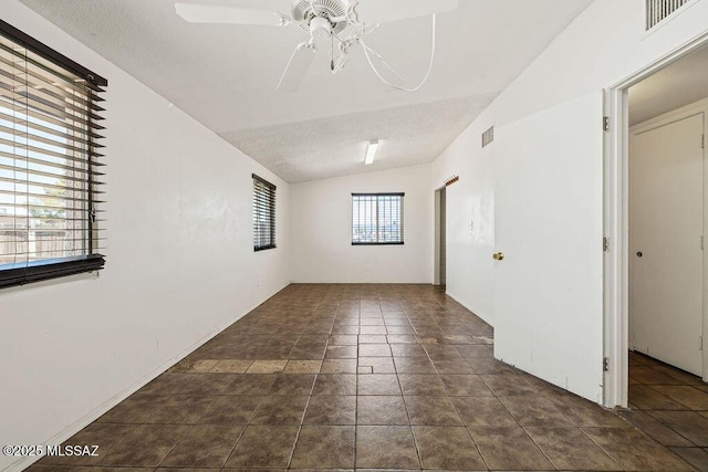 unfurnished room featuring lofted ceiling, a textured ceiling, ceiling fan, and visible vents