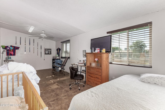 bedroom with ceiling fan and a textured ceiling