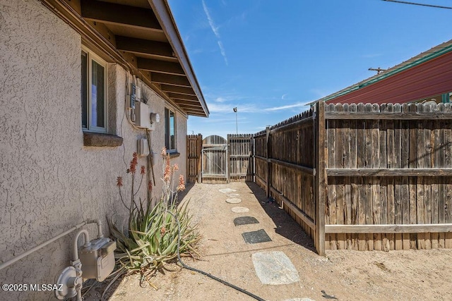 view of property exterior featuring a gate, fence, and stucco siding