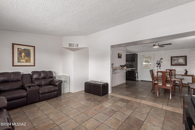 living room featuring a textured ceiling and ceiling fan