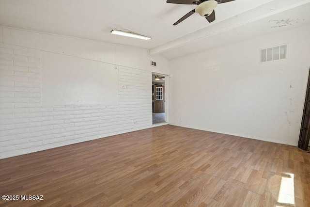 unfurnished room featuring lofted ceiling with beams, a ceiling fan, visible vents, and wood finished floors