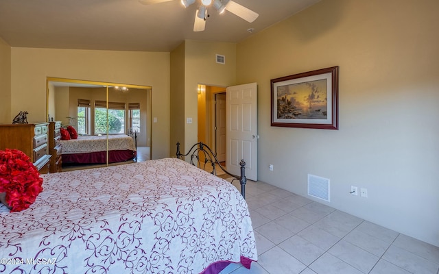 tiled bedroom featuring a closet, ceiling fan, and lofted ceiling