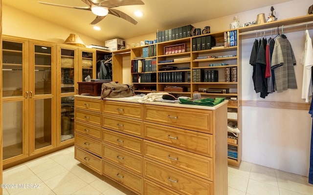 walk in closet with light tile patterned floors, ceiling fan, and lofted ceiling