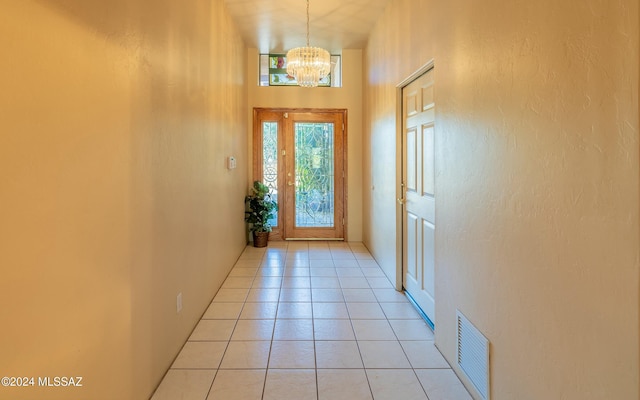 doorway featuring a chandelier and light tile patterned floors