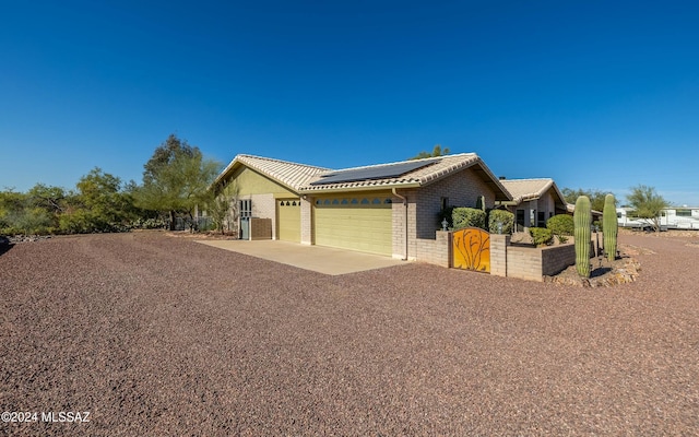 view of front of home with solar panels and a garage