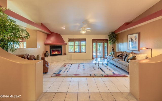 tiled living room featuring ceiling fan, lofted ceiling, and a fireplace