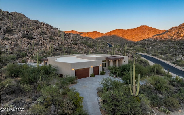 15251 N Dove Canyon Pass, Marana, AZ 85658 - view of front facade with an attached garage, stucco siding, a mountain view, and concrete driveway