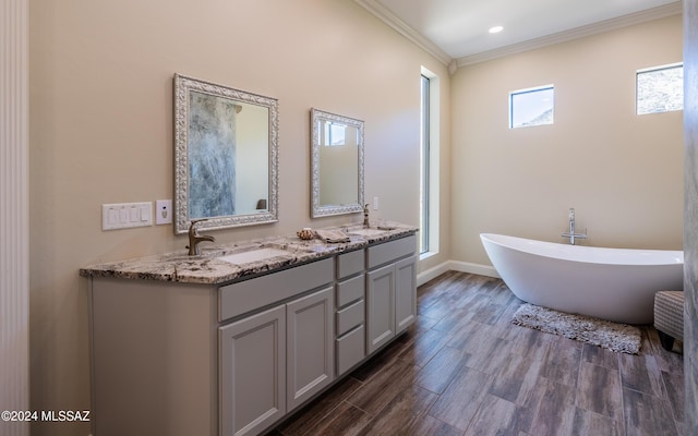 15251 N Dove Canyon Pass, Marana, AZ 85658 - bathroom featuring double vanity, a freestanding bath, ornamental molding, wood finished floors, and baseboards