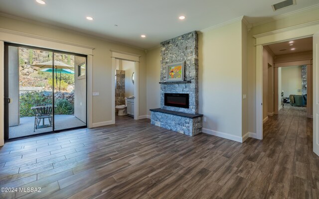 15251 N Dove Canyon Pass, Marana, AZ 85658 - unfurnished living room featuring ornamental molding, dark wood-type flooring, a stone fireplace, baseboards, and recessed lighting