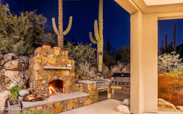 15251 N Dove Canyon Pass, Marana, AZ 85658 - patio at night featuring an outdoor stone fireplace