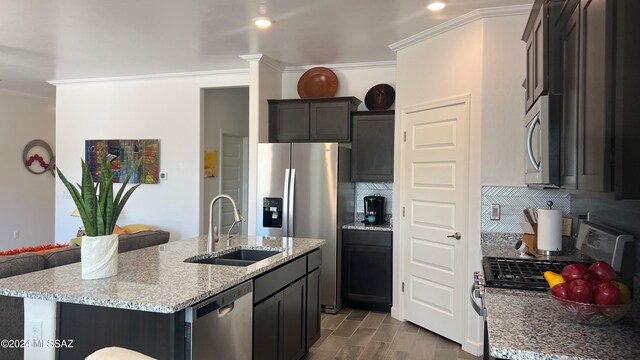 kitchen featuring tasteful backsplash, sink, an island with sink, and stainless steel appliances