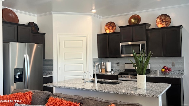 kitchen with tasteful backsplash, sink, an island with sink, and stainless steel appliances