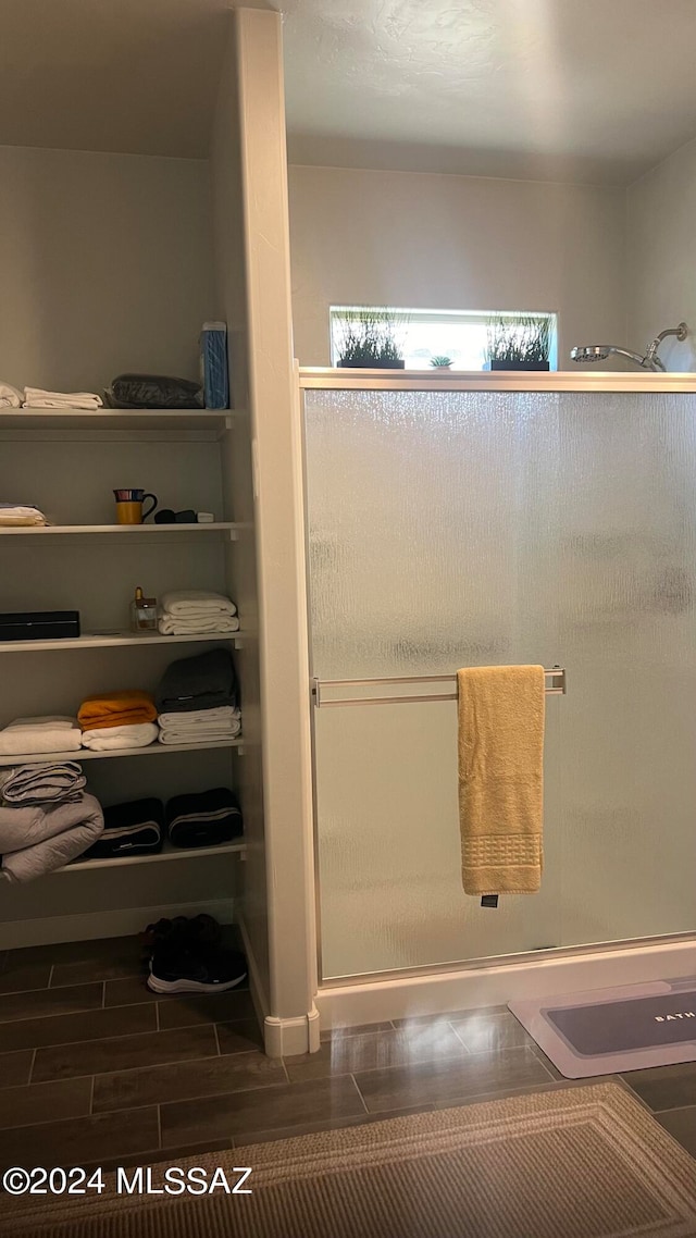 bathroom with a shower with door and hardwood / wood-style floors