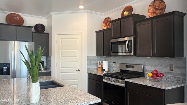 kitchen featuring decorative backsplash, light stone counters, crown molding, and appliances with stainless steel finishes